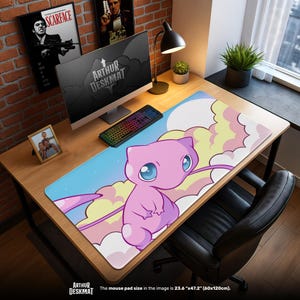 May include: A rectangular desk mat featuring a cartoon character in pink with large blue eyes, set against a sky and cloud background. The mat is labeled "ARTHUR DESKMAT" and measures 23.6" x 47.2".