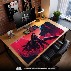 May include: A large, rectangular mouse pad with a red and black anime-style illustration. The artwork features a warrior facing a large wolf against a red background. The mouse pad measures 23.6" x 47.2". The text "ARTHUR DESKMAT" is visible.