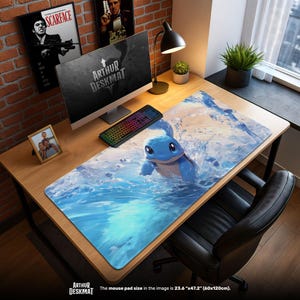 May include: A large rectangular desk mat featuring a blue cartoon character in water. The mat has a blue and white water design. The text "ARTHUR DESKMAT" is visible. The mouse pad size is 23.6" x 47.2".