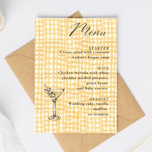May include: A wedding menu card with a yellow checked pattern and stylish script. The menu details starters, mains, and desserts, such as Caesar salad, chicken marsala, and wedding cake. A martini glass illustration is included.