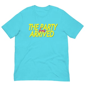 Könnte beinhalten: Ein türkisfarbenes T-Shirt mit dem Text "THE PARTY has ARRIVED" in Gelb, umrandet von Schwarz, und dem Wort "has" in Pink. Das T-Shirt hat kurze Ärmel und einen Rundhalsausschnitt.