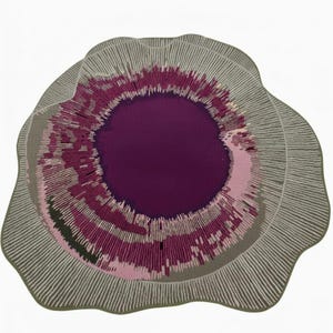 Könnte beinhalten: Ein runder Teppich mit einzigartigem Design. Die Mitte ist ein tiefes Lila, umgeben von konzentrischen Ringen aus Rosa, Grau und Grün. Der äußere Rand ist hellgrau mit weißen linearen Mustern, was einen strukturierten, künstlerischen Look erzeugt.