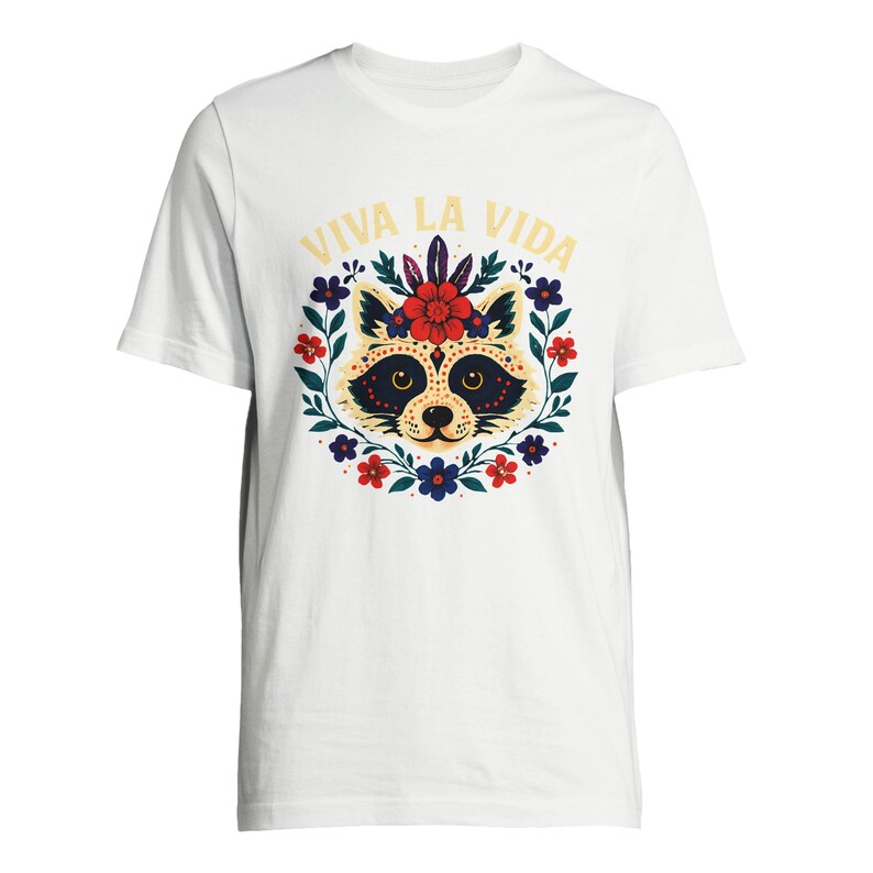 May include: White t-shirt featuring a raccoon face design with a floral wreath and the text "VIVA LA VIDA" in yellow. The raccoon has a decorative face with a flower crown. The design is centered on the shirt.