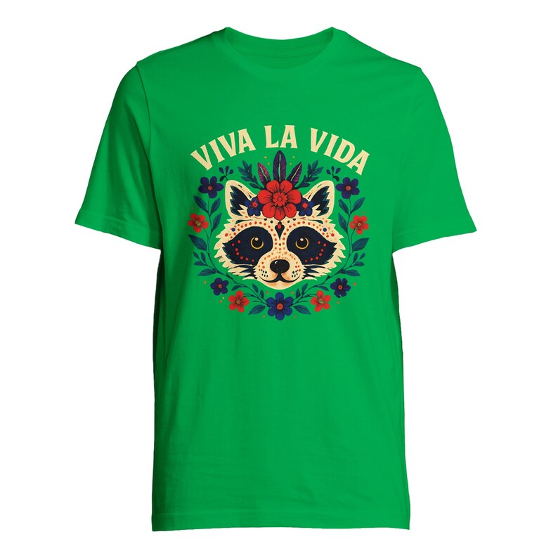 May include: Green t-shirt featuring a raccoon design with a floral wreath and the text "VIVA LA VIDA" in white. The raccoon has a decorative face with a flower crown. The shirt is a vibrant green color.