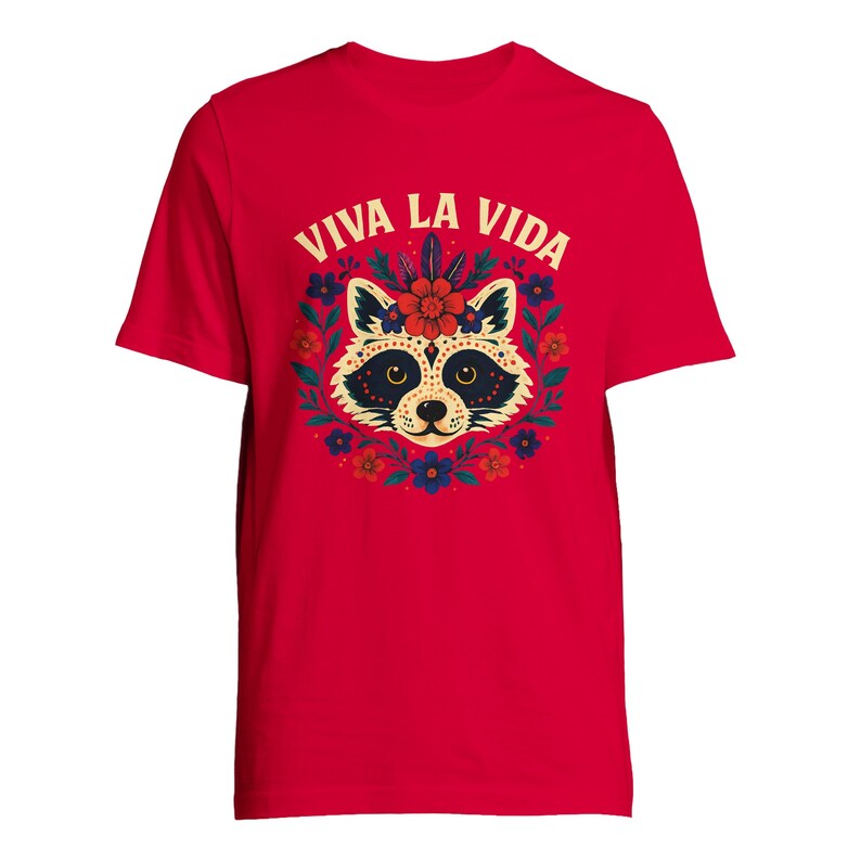May include: A red t-shirt featuring a raccoon design with floral accents and the text "VIVA LA VIDA" in white. The raccoon has a decorative floral crown and is surrounded by a wreath of flowers. The shirt is a short-sleeved crew neck.
