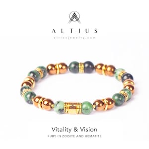 Op de afbeelding: Een armband met groene zoisiet, koperkleurige hematiet en goudkleurige kralen. De armband is voorzien van het label "Vitality & Vision" en is van Altius Jewelry.