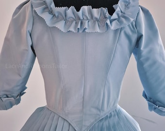 May include: A light blue bodice with a square neckline, featuring a ruffled collar and three-quarter length sleeves with ruffled cuffs. The garment has a pointed waistline and vertical seams, with the text LaceAndRibbonsTailor visible on the left.