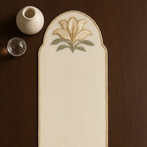 Puede incluir: Camino de mesa de cuentas de color crema con diseños florales en cada extremo. Las flores son en tonos dorados y verdes, con un borde de cuentas. El camino de mesa mide unos 76 cm de largo.