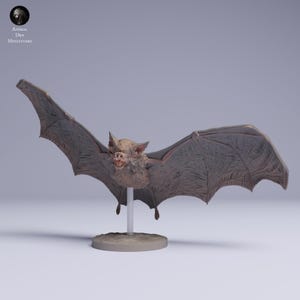 May include: A detailed miniature bat figurine with outstretched wings, showcasing intricate wing textures and a detailed face with visible teeth. The bat is mounted on a small, round base with a support rod, and is likely a collectible item.