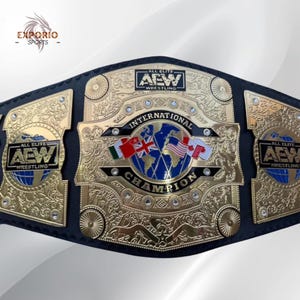 May include: A gold-plated AEW International Championship wrestling belt featuring a black leather strap, intricate filigree engravings, and a central circular emblem displaying a blue world map with various national flags and the text International Champion.
