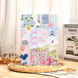 Può includere: Una custodia decorativa per tablet con un collage di motivi floreali e nautici. La custodia include un faro, tulipani rosa, ortensie blu e la scritta "meet me in Charleston". La custodia è su un tappetino intrecciato.