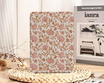 Peut inclure: Une couverture de livre rectangulaire à motifs floraux. Le motif présente des fleurs roses et des tiges marron sur un fond crème. La couverture du livre est présentée sur un tapis tissé, avec un arrière-plan flou.