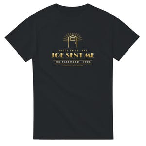 May include: A black short-sleeve t-shirt featuring a gold graphic of a door with rays above it. The text reads: KNOCK TWICE SAY JOE SENT ME THE PASSWORD 1920s. The design is centered on the chest, utilizing a clean, bold font with horizontal lines.
