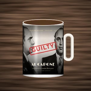 May include: A white ceramic mug featuring a black and white mugshot of Al Capone in profile and front view. The text reads Booking Record Chicago 1931, Al Capone, Convicted of tax evasion. Eleven years, National Crime Syndicate, and a red stamp GUILTY.