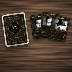 May include: A Made Men mob battle card game set featuring a black and gold deck box with sunburst patterns and three playing cards displaying black and white portraits of Lucky Luciano, Albert Anastasia, and Bugsy Siegel with statistical data.