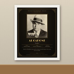 May include: A black and gold framed poster featuring a vintage mugshot of Al Capone wearing a fedora and suit. The text includes his name, nickname Scarface, birth and death dates, and a brief historical summary of his 1929 arrest in Philadelphia.