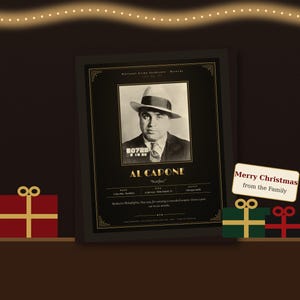 May include: A framed black and gold poster featuring a vintage mugshot of Al Capone with the text Al Capone Scarface and Merry Christmas from the Family. The design includes biographical details and a decorative border on a dark background.