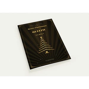 May include: A rectangular Christmas greeting card featuring a black and gold sunburst background. The text reads Season's Greetings, Merry Christmas from the Moretti Family, and It's a family thing. A stylized gold Christmas tree is centered.