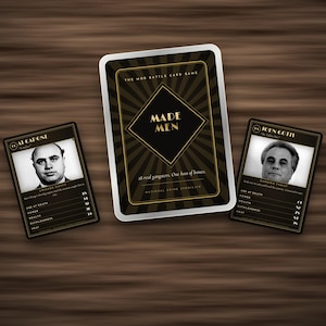 Pode incluir: Um conjunto de jogo de cartas intitulado Made Men com uma caixa central com gráficos de raios de sol em preto e dourado, ladeada por duas cartas de personagem exibindo retratos em preto e branco de Al Capone e John Gotti com estatísticas.