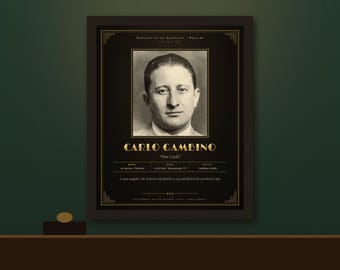 Op de afbeelding: Een ingelijste zwart-gouden poster met een sepia-kleurig portret van Carlo Gambino. De tekst bevat National Crime Syndicate Records, de naam Carlo Gambino, Don Carlo, geboorte- en sterfdata en een korte biografische samenvatting.
