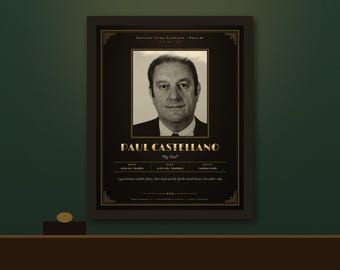 Op de afbeelding: Een ingelijste zwart-gouden poster met een portret van Paul Castellano, getiteld "Big Paul". De tekst bevat "National Crime Syndicate Records", geboorte- en sterfdata en een notitie over zijn overlijden buiten het Sparks Steak House.