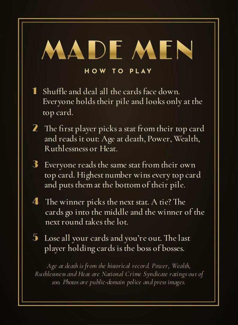 May include: A black instructional card for the game Made Men with gold text and borders. It lists five numbered steps for gameplay, explaining how to shuffle, deal, compare stats like Age at death, Power, Wealth, Ruthlessness, and Heat.