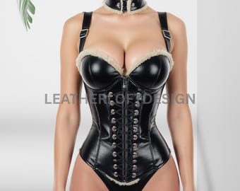 May include: Black faux leather corset with a fur trim and a matching choker. The corset features a front zipper, adjustable straps, and a lace-up back. The text "LEATHER OF DESIGN" is visible on the image.