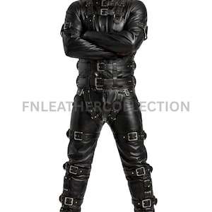 May include: A black leather full-body suit featuring a high collar, long sleeves, and integrated trousers. The garment is adorned with numerous horizontal straps and silver-toned metal buckles across the chest, waist, thighs, and lower legs.