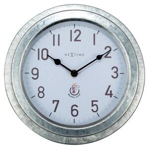 Op de afbeelding: Een ronde, zilverkleurige wandklok met een witte wijzerplaat. De klok heeft zwarte wijzers en bruine cijfers. De wijzerplaat heeft de tekst "NEXTIME" en "Weather proof". De klok heeft een diameter van ongeveer 25 cm.