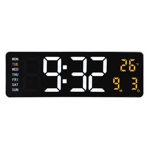 Könnte beinhalten: Schwarze Digitaluhr, die 9:32 Uhr anzeigt, mit dem Wochentag links und der Temperatur in Grad Celsius rechts. Die Uhr zeigt auch das Datum an.