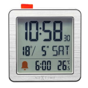 May include: A silver digital alarm clock with a rectangular face and rounded corners. The display shows the time as 10:58, the date, and the alarm time. The clock has a red button on top and the brand name "NEXTIME" at the bottom.