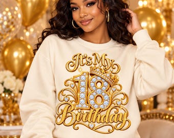 Könnte beinhalten: Ein cremefarbenes Sweatshirt mit Rundhalsausschnitt und einem großen Grafikdruck, der It's My 18 Birthday in goldener Schrift zeigt. Das Design umfasst eine juwelenbesetzte Krone und die Zahl 18 mit funkelndem Diamantmuster.