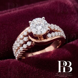 May include: A rose gold ring featuring a large, round, brilliant-cut center diamond held by four prongs. The band is split into two rows, each encrusted with small, round, pavé-set diamonds that extend along the sides of the central stone.