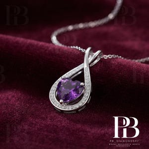 May include: A silver-toned pendant necklace featuring a heart-shaped purple gemstone set within a teardrop-shaped frame. The frame is accented with small, clear pavé stones along the outer edge and a twisted metal design at the top bail.
