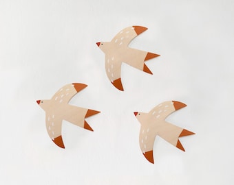 Ensemble de trois oiseaux décoratifs en bois. Accrochez ces hirondelles à votre mur et égayez votre maison !