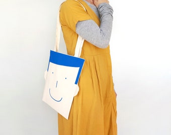 Unique gifts for women: a reusable canvas tote bag for shopping with a smile. Fun tote bag with a smiling face