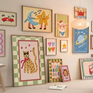May include: A collection of framed art prints with whimsical illustrations. The prints feature a variety of themes, including a cheetah with sunglasses, a car, a moon and star, and the text "YES YOU CAN". The color palette includes pink, green, and yellow.