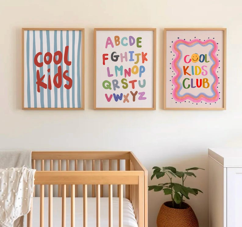 May include: Three framed art prints with a children's theme. One print has blue and white vertical stripes with the words "cool kids" in red. Another features the alphabet in colorful letters. The third print says "cool kids club" with a smiley face.