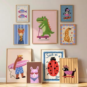 May include: A gallery wall set of nine framed art prints featuring colourful illustrations of animals including a green crocodile on a scooter, a bear with a surfboard, a ladybug with the text Snug as a Bug, a zebra, a giraffe, and a dog.