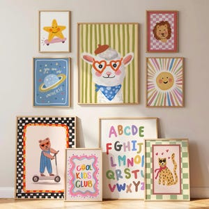 May include: A collection of framed art prints featuring whimsical illustrations. The artwork includes a star on a skateboard, a planet, a llama with heart-shaped glasses, a lion, a sun, a bear on a scooter, the text "COOL KIDS CLUB", an alphabet, and a cheetah.