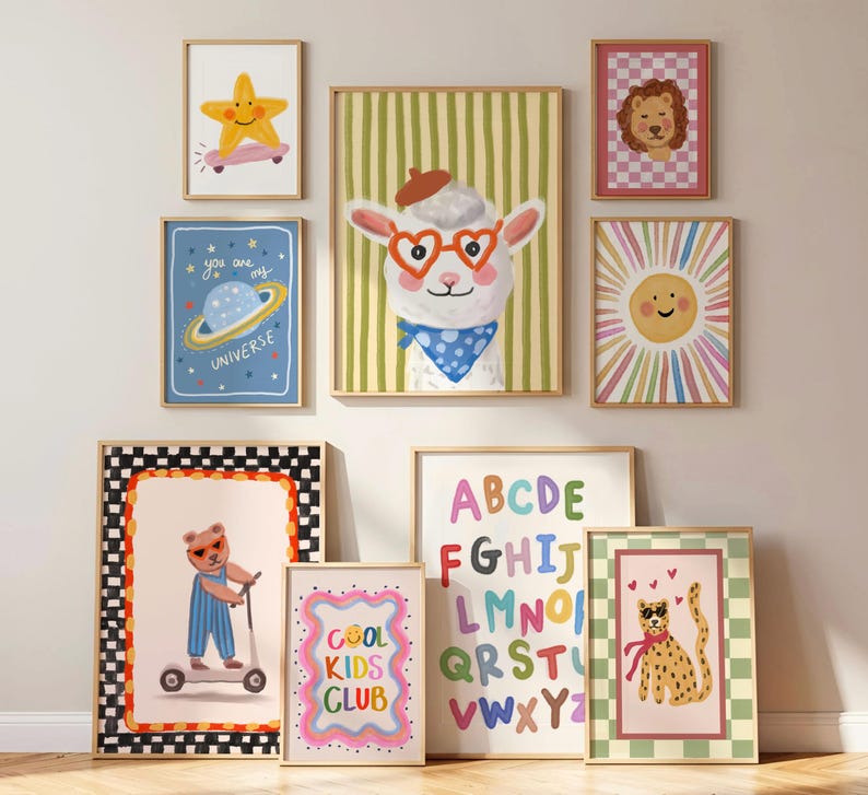 May include: A collection of framed art prints featuring whimsical illustrations. The artwork includes a star on a skateboard, a planet, a llama with heart-shaped glasses, a lion, a sun, a bear on a scooter, the text "COOL KIDS CLUB", an alphabet, and a cheetah.