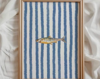 May include: A framed art print featuring a watercolor illustration of a fish. The background has vertical blue and white stripes. The frame is a light gold color. The fish has yellow, silver, and blue tones.