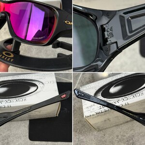 May include: Black Oakley sunglasses with a glossy finish and vibrant pink lenses. The frames feature the Oakley logo and text. The sunglasses are displayed with their original packaging, including a black case and a microfiber cloth.