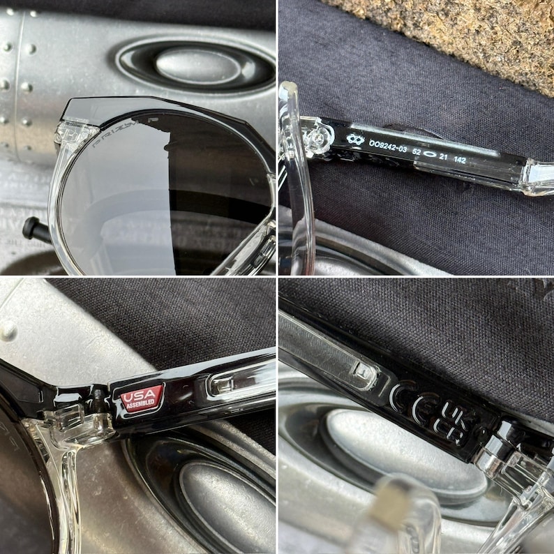 May include: Clear-framed sunglasses with dark lenses. The glasses have a round shape and a transparent frame. The temples have the text "USA ASSEMBLED" and the model number "OO9242-03 52 21 142".