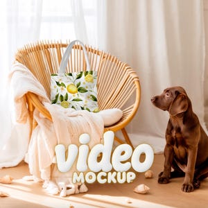 Può includere: Una borsa tote bianca con un motivo a limoni e fiori è in una sedia di vimini. La borsa presenta limoni gialli, foglie verdi e fiori bianchi. Le parole "video MOCKUP" sono in lettere bianche e gonfie. Un cane marrone è vicino.