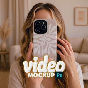 Può includere: Una custodia per telefono beige con un motivo floreale bianco è tenuta davanti a un volto. La custodia del telefono ha una fotocamera a tre obiettivi. Le parole "video MOCKUP Ps" sono visualizzate in 3D nella parte inferiore del telefono.