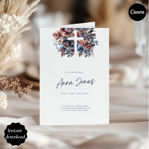 May include: A white funeral card featuring a floral cross design. The card reads "In Loving Memory" and includes the name "Anna Jones" with dates. The bottom text states "A Catholic Funeral Mass to Honour and Celebrate a Life of Faith, Love, and Grace."