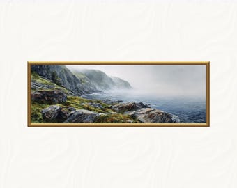 May include: A framed landscape painting depicts a coastal scene with rocky cliffs, green vegetation, and a misty ocean. The artwork features a gold-colored frame and a serene, naturalistic style, evoking a sense of tranquility and the beauty of nature.