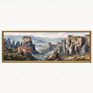 May include: A framed landscape painting depicts a mountain range with a monastery. The artwork features a gold frame and showcases a detailed watercolor style. The color palette includes shades of brown, green, and blue, creating a serene atmosphere.