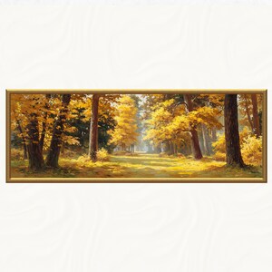 May include: A framed landscape painting of an autumnal forest scene. The artwork shows trees with golden yellow leaves, a path leading into the distance, and a warm colour palette. The frame is a warm gold colour.